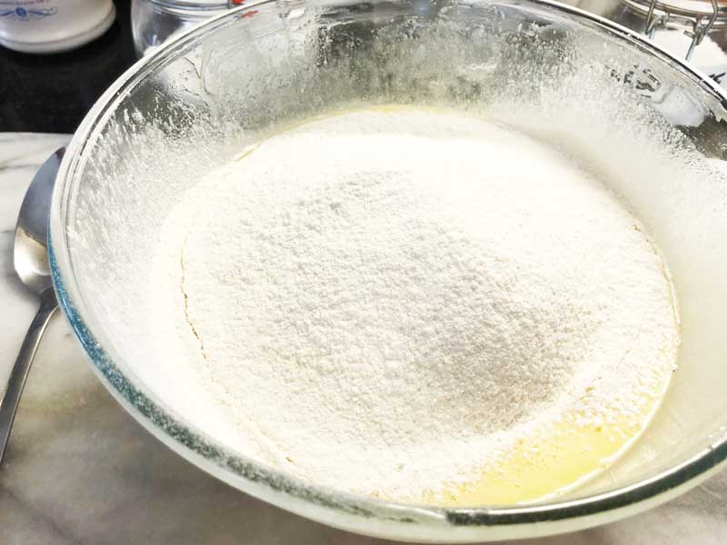 Sieving flour into the white chocolate, butter and eggs