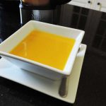 A white porcelain soup bowl filled with sweet potato and squash soup
