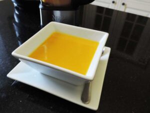 A white porcelain soup bowl filled with sweet potato and squash soup